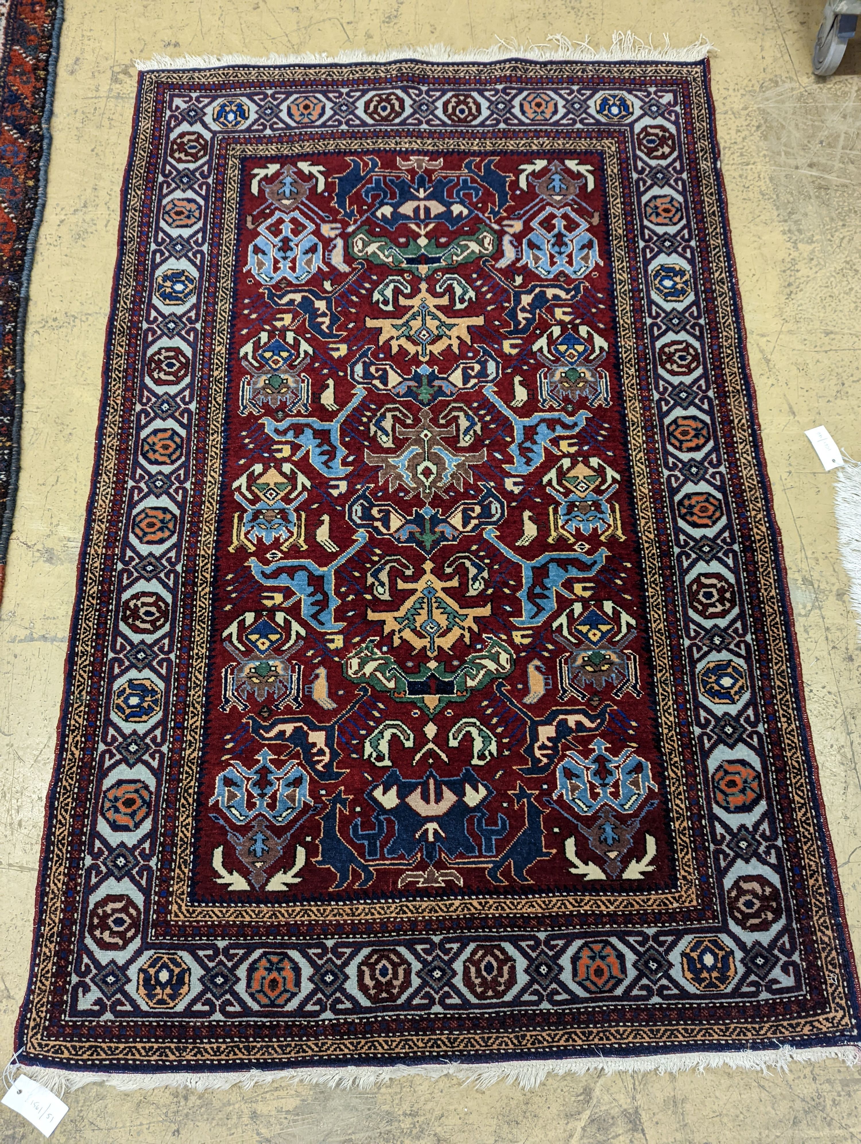 A Caucasian design burgundy ground rug, 153 x 100cm